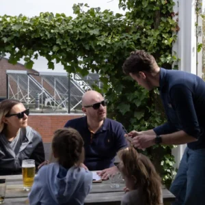 Hessel serveert gasten op het voorterras van restaurant Het Raadsel van de Wadden in Oostmahorn Friesland