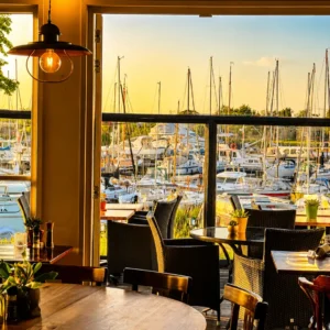 Uitzicht vanuit de serre van restaurant Lauwersmeer Het Raadsel van de Wadden bij zonsondergang in de jachthaven van Oostmahorn Friesland